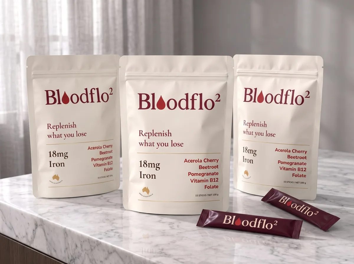 Three bags of Bloodflo Replenish on a kitchen bench with stick sachets in front. The first bag is free.
